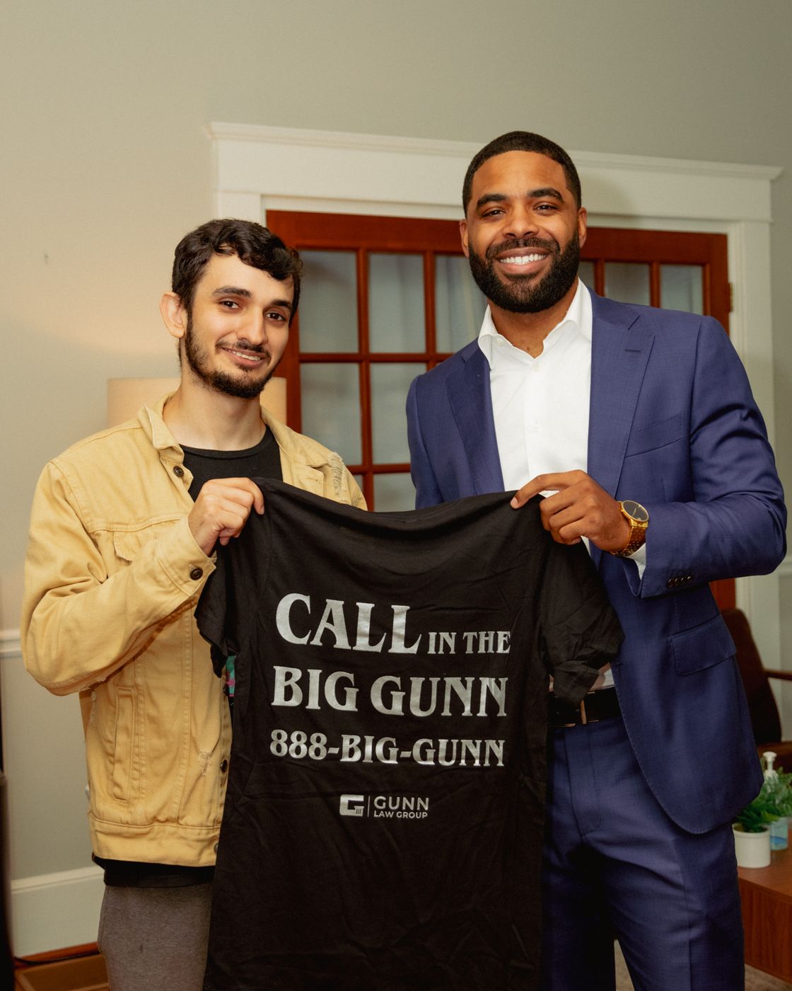 Attorney Harrell Gunn with a client holding a Call in the Big Gunn t-shirt